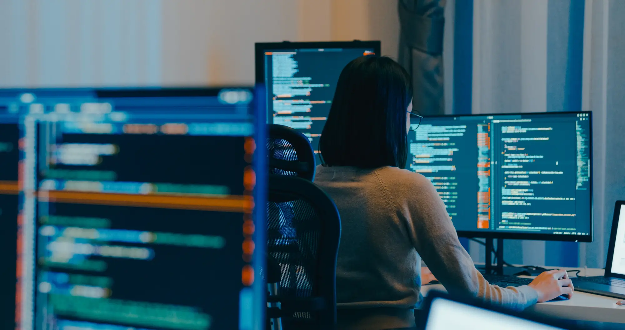 Developer working at multiple computer monitors
